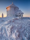 Karpacz, Poland, December 18, 2022 - Snow-covered Chapel of Saint Lawrence on Mount Sniezka before sunrise. Karkonosze